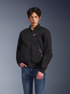 Alpinestars Flight Air Jacket, Black Urban Motorcycle Jacket, worn by a man with blue jeans, featuring a bomber-style aesthetic with mesh panels, front zipper, and white logo on the chest, designed for hot-weather city riding