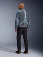 Alpinestars Flight Air-jacka, stormgrå motorcykeljacka, sedd bakifrån, med ventilationspaneler i 3D-mesh och vertikal vit Alpinestars-logotyp, bärs med svarta byxor och svarta sneakers, urban pendlingsstil