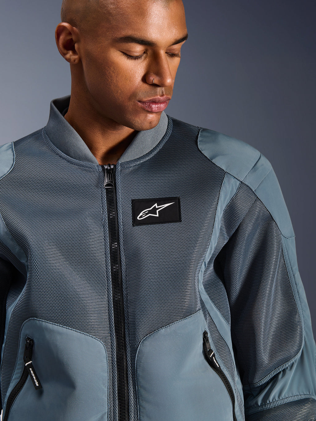 Alpinestars Flight Air-jacka, Storm Gray, urban motorcykeljacka, med 3D-meshpaneler och ribbad krage i bombermodell, svart Alpinestars-logotyp på bröstet, teknisk textil med god andningsförmåga för pendling i varmt väder