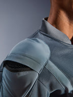 Närbild på Alpinestars Flight Air Jacket i Storm Gray, som visar den yttre axelskyddsfickan med synligt bikakeformat skydd, 3D-meshpaneler och ribbad krage för teknisk urban motorcykelkörning.
