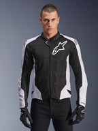 Alpinestars Viper Air V4 Jacket, Motorcycle Racing Jacket, Black and White, worn by rider, tech mesh and textile construction with white shoulder panels, prominent star logo on chest, sport performance design, paired with black riding gloves