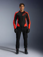 Manlig modell som bär Alpinestars Viper Air V4-jacka i Red Fluo och svart, kombinerad med svarta körbyxor, handskar och stövlar, med meshpaneler som andas för ventilation och en tydlig stjärnlogotyp på bröstet, sportig motorcykelutrustning för vägkörning