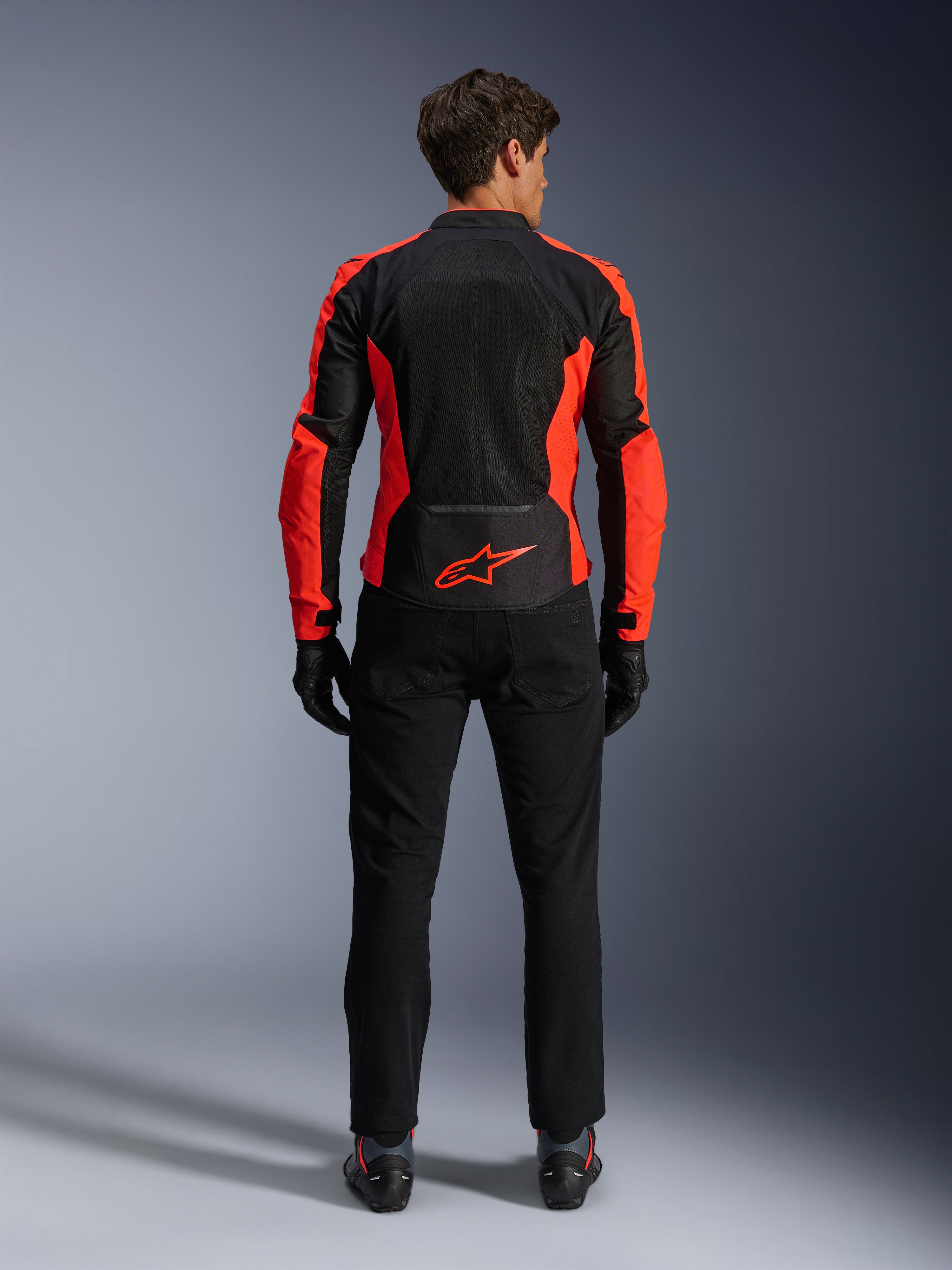 Alpinestars Viper Air V4-jacka, Red Fluo och svart, baksida som visar stora tekniska meshpaneler och klaröda fluorescerande sidoaccenter, röd Alpinestars-logotyp på nedre ryggen, bärs med svarta mc-byxor och handskar.
