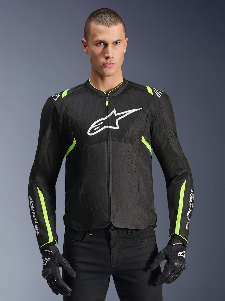 Alpinestars T-Sps Air V2-jacka i Black Yellow Fluo, manlig modell som bär den ventilerade textiljackan med meshpaneler och vit logotyp på bröstet, matchad med svarta mc-handskar, urban mc-utrustning