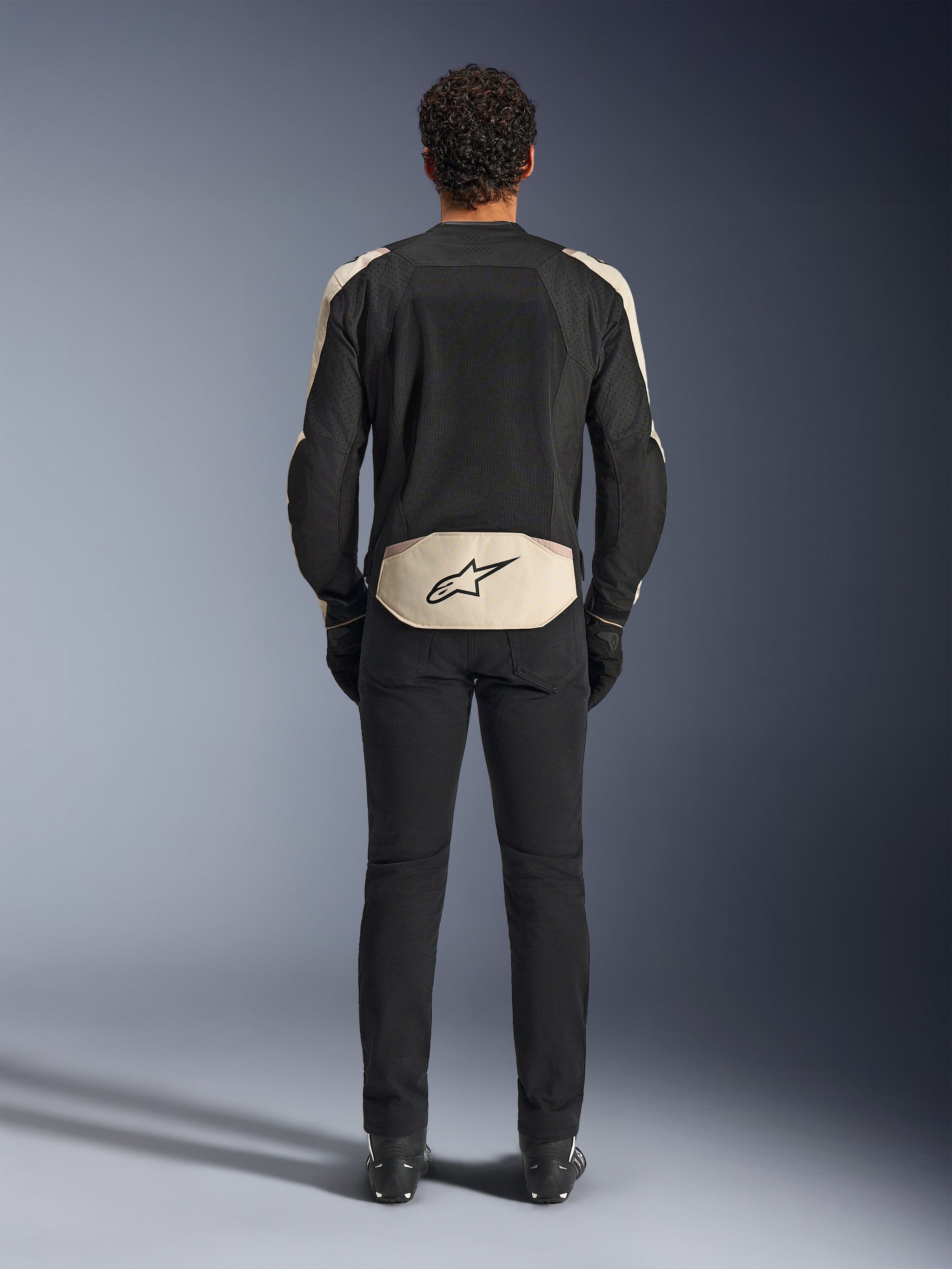 Alpinestars T-SPS Air V2-jacka, baksida, Black Mastic Aluminum, textil mc-jacka med stora meshpaneler för ventilation, ljusbeige detaljer på axlar och nedre rygg med Alpinestars-logotypen, bärs med svarta mc-byxor och stövlar