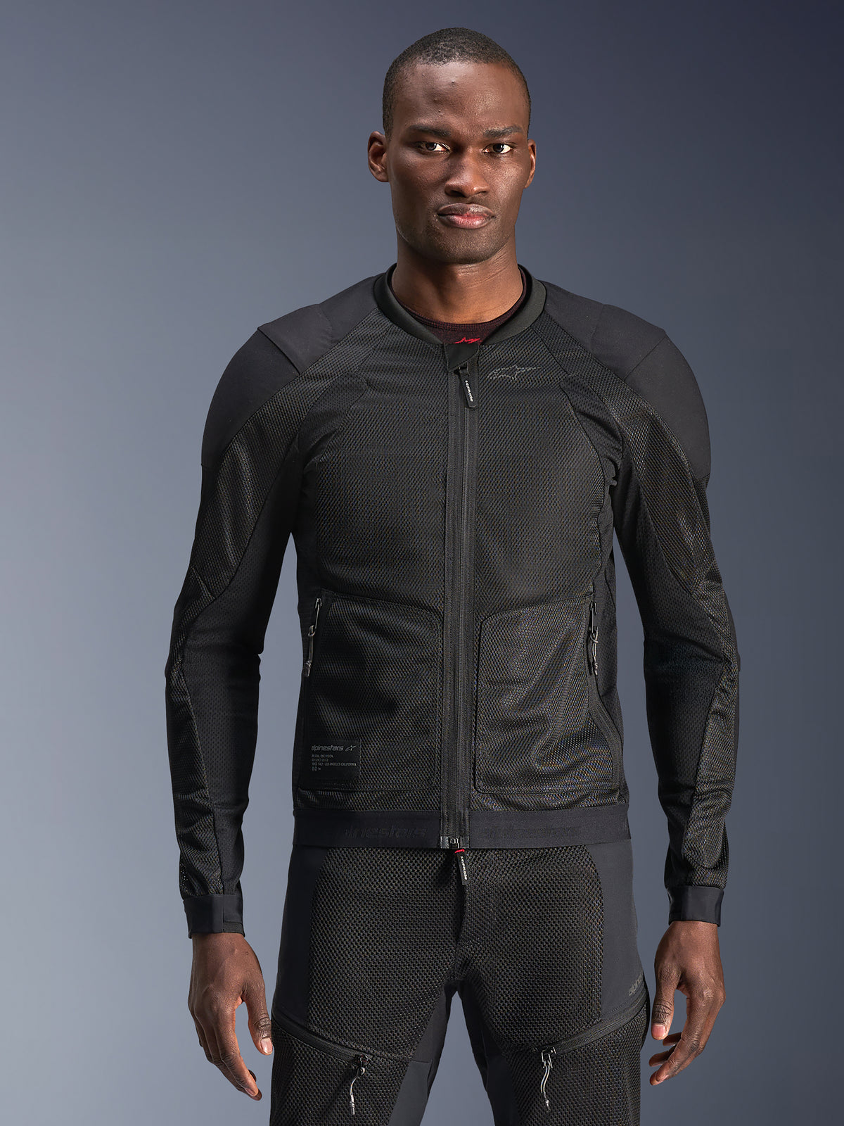 Alpinestars Troop-Air jacka, herrmotorcykeljacka i svart mesh, bärs av modell för andningsbar urban körning.