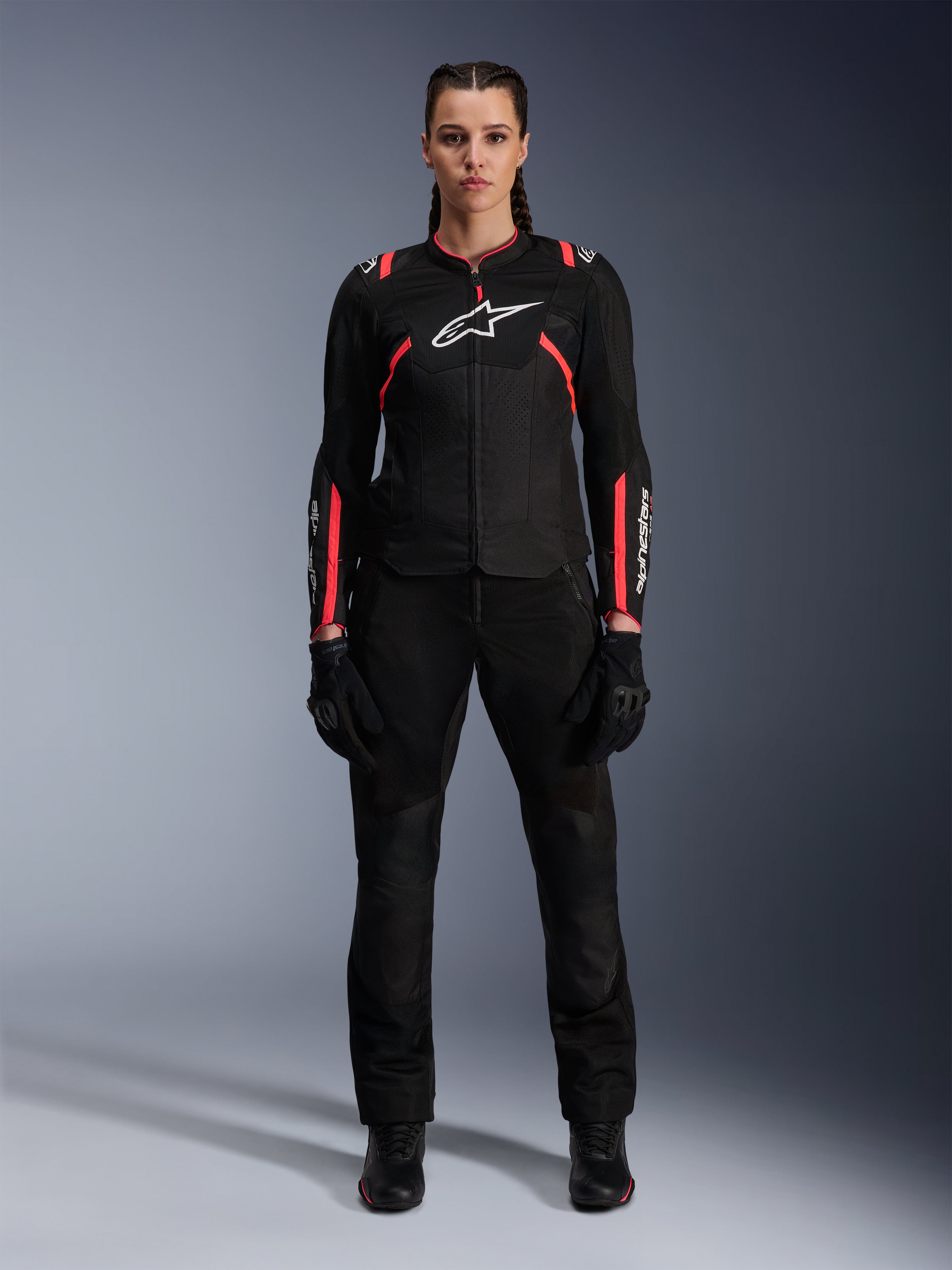 Alpinestars Stella T-SPS Air v2-jacka, motorcykeljacka för dam, svart och Diva Pink, sedd framifrån, vit logotyp på bröstet, ventilationspaneler i mesh, bärs med svarta byxor och handskar, stilren urban körutrustning