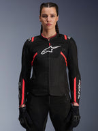 Alpinestars Stella T-Sps Air V2-jacka för dam, Black Diva Pink, motorcykeljacka i textil med meshpaneler med god andningsförmåga och rosa detaljer, vit Alpinestars-logotyp på bröstet, bärs av en kvinnlig modell med svarta mc-byxor och handskar
