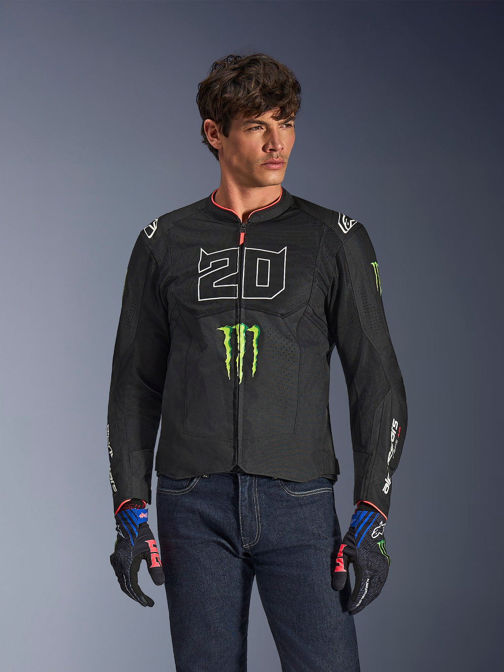 Alpinestars FQ20 T-SPS Air V2 Monster-jacka, svart motorcykeljacka med stor vit '20' och grön Monster Energy-logotyp, bärs av en manlig modell med mörka jeans och matchande handskar, lättviktig mesh-konstruktion för stadskörning
