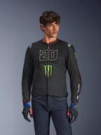 Alpinestars FQ20 T-SPS Air V2 Monster-jacka, svart motorcykeljacka med stor vit '20' och grön Monster Energy-logotyp, bärs av en manlig modell med mörka jeans och matchande handskar, lättviktig mesh-konstruktion för stadskörning