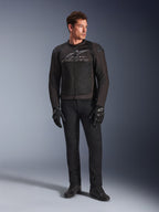 Manlig modell som bär Alpinestars SMX Air Jacket, motorcykeljacka i färgen Black Anthracite med ventilerade meshpaneler och grå logotyp på bröstet, matchad med svarta byxor och skyddshandskar, studiomiljö med tonad bakgrund