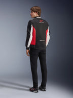 Alpinestars Monza Sport-jacka, textiljacka för motorcykel, svart, klarröd och vit, ryggvy av modell med röda sidopaneler och vita ärmdetaljer, Alpinestars-logotyp och texten 'ONE GOAL. ONE VISION.', kombinerad med svarta byxor och körskor för en sportinspirerad look