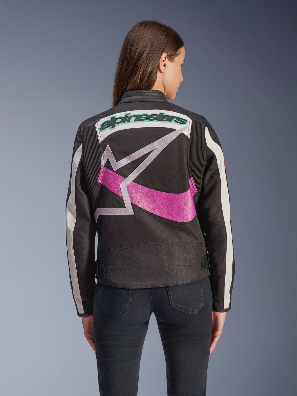 Alpinestars Idles damjacka, sedd bakifrån, svart, off-white och lila, stor grafisk stjärnlogotyp på ryggen, turkos broderad text, dragspelspaneler på axlarna, vintageinspirerad urban motorcykelutrustning