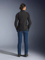 Stella Aeroshell Airflow-jacka för dam, Black Anthracite, vy bakifrån på en modell, med ett lätt softshell-chassi med laserperforerade meshpaneler, förlängd bakre profil för täckning, sportig körpassform, kombinerad med blå jeans.