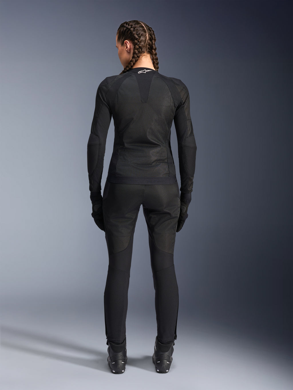 Alpinestars Stella Troop-Air Jacket, Women's Motorcycle Jacket, Black, back view of a rider wearing a technical mesh jacket, paired with matching black riding pants, gloves, and boots, slim-fitting breathable design with a white Alpinestars logo on the collar