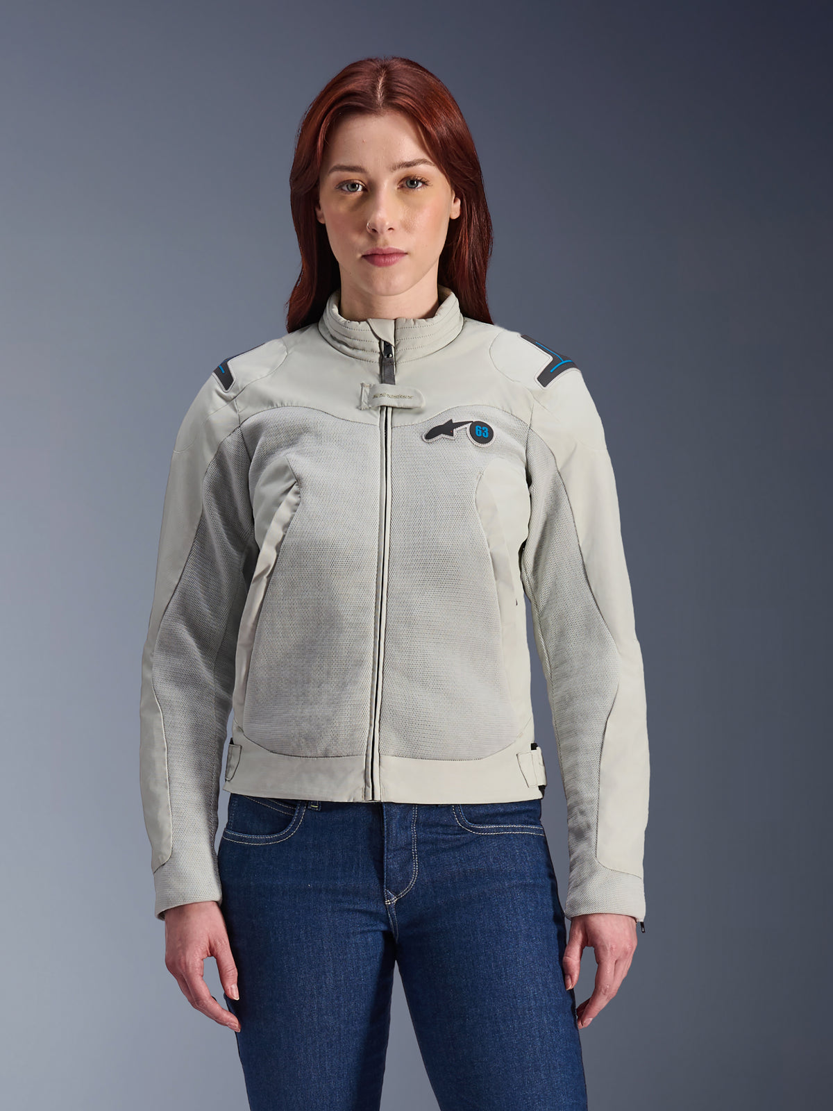 Alpinestars Stella Circal-1 Air Jacket, motorcykeljacka för dam, metallgrå med blå detaljer, meshpaneler för luftflöde, dragkedja fram med stående krage, bärs av modell över mörkblå jeans