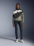 Alpinestars Stella Moshell-jacka, motorcykeljacka för dam, svart, grå och off-white med rosa detaljer, bärs av en modell med mörka jeans och off-white sneakers, med asymmetrisk dragkedja och djärv geometrisk grafik, modern urban mc-utrustning