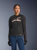 Kvinna i Alpinestars Stella SMX Air-jacka, Black White Red Fluo, textiljacka för motorcykel med ventilerande mesh och vit logotyp på bröstet, stylad med blå jeans och svarta mc-handskar, feminin passform för sportkörning