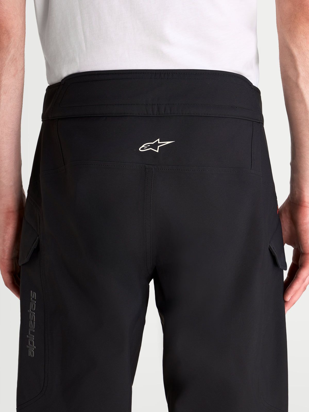 Alpinestars Juggernaut V2 Drystar byxor, svarta vattentäta motorcykelbyxor för stadskörning, vy bakifrån som visar hög midja, ergonomisk sätesstruktur, vit Alpinestars-logotyp och sidofickor på modell