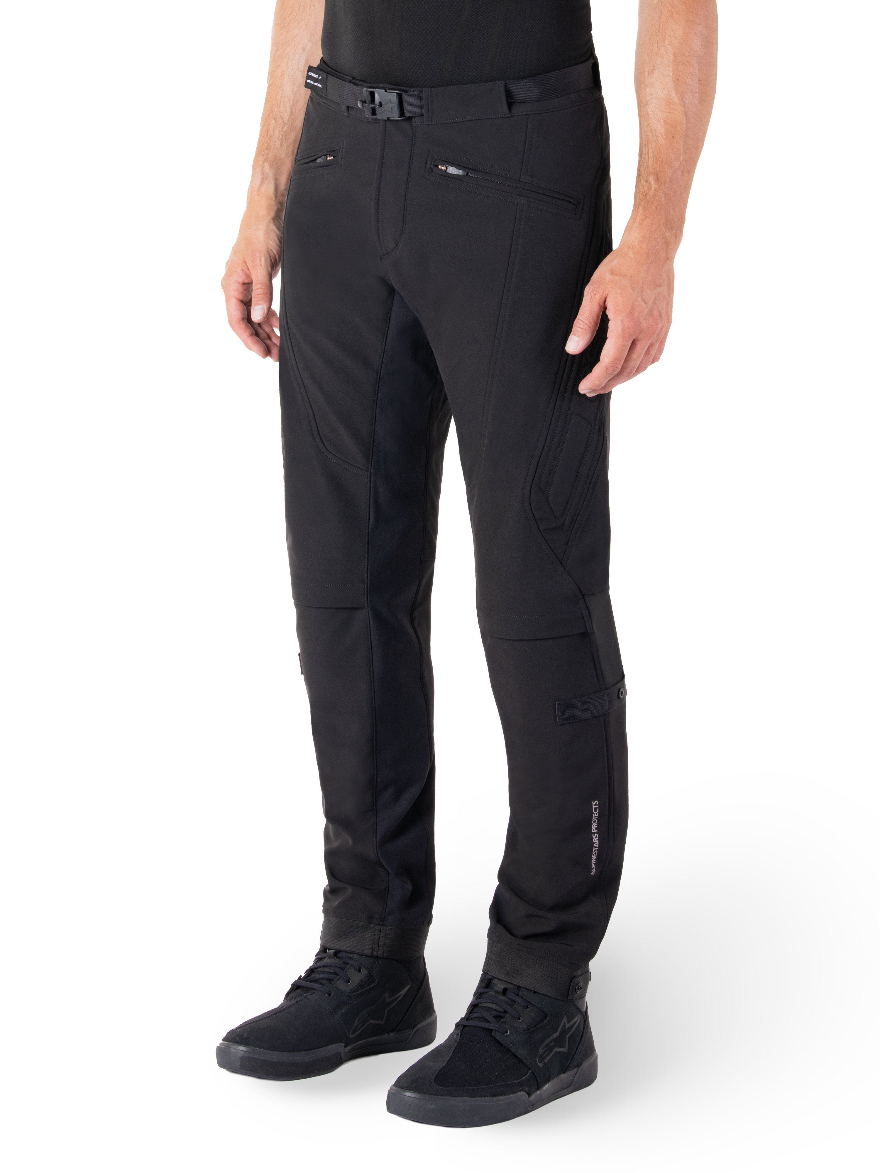 Alpinestars Alden Pants, Urban Motorcycle Pants, Black, technical softshell fabric with regular fit, featuring magnetic waist buckle, quilted side panels, zippered pockets, and subtle branding on the lower leg, worn with black riding shoes