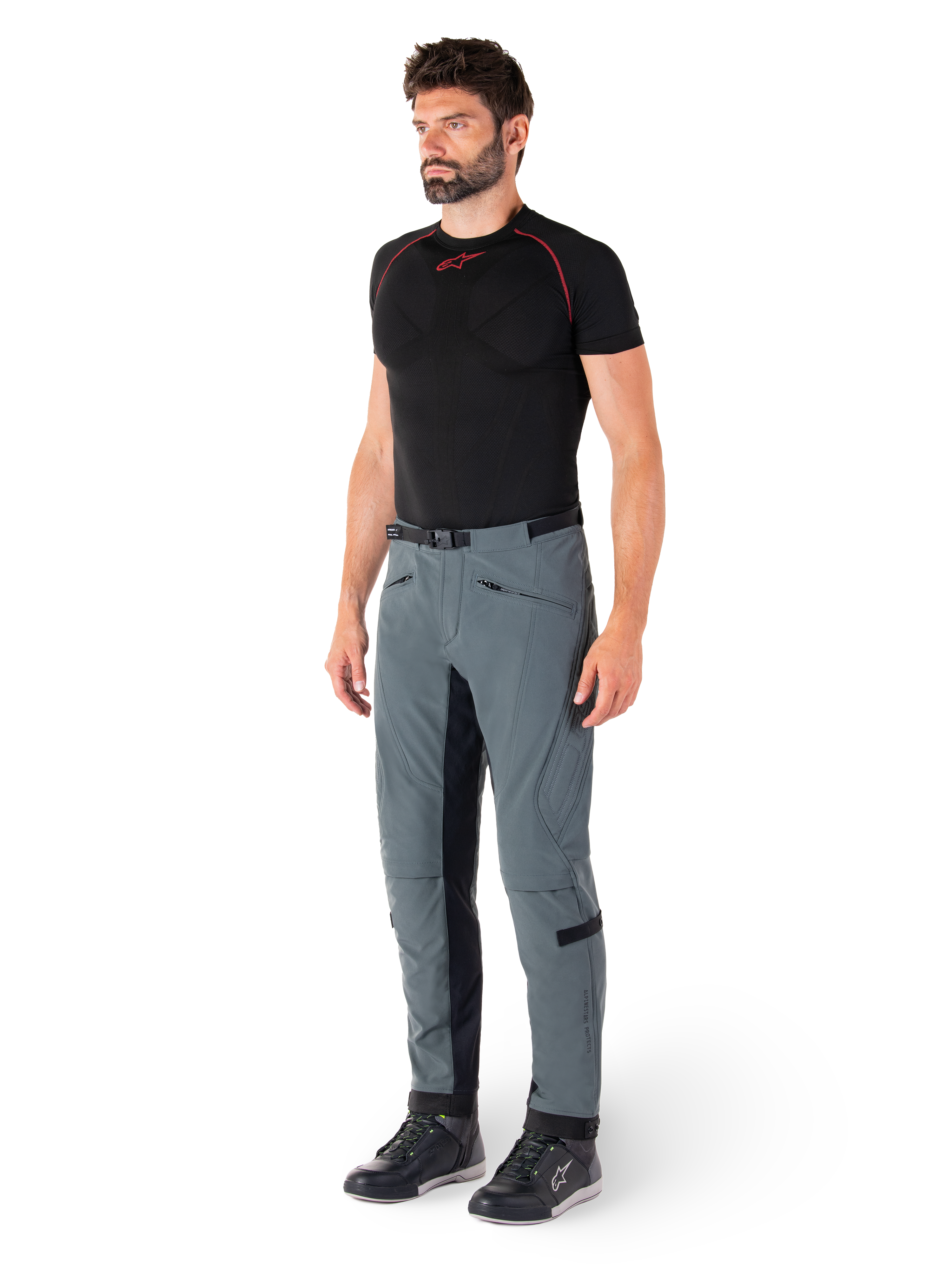 Alpinestars Alden-byxor, tekniska motorcykelbyxor i Urban Gray, med kviltade sidopaneler och svart stretchtyg på innerbenen, stylade med ett svart underställ och mc-skor, streetwear-inspirerad urban mc-utrustning