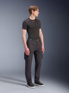 Manlig modell som bär Alpinestars Flex-AST Cargo Pants - Short i svart, urbana motorcykel-cargobyxor med sidofickor och avsmalnande ben, stylade med en svart underställströja och sneakers, urban mc-utrustning.
