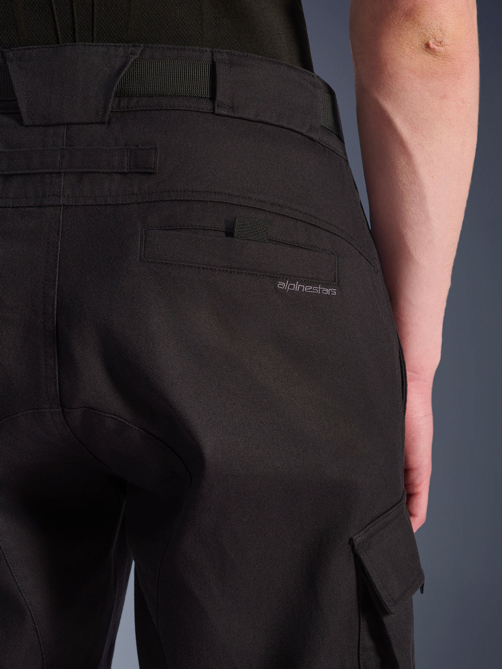Närbild på Alpinestars Flex-AST Cargo Pants i svart, urbana motorcykelbyxor med en detaljerad bakficka med diskret märkning, stora bältesöglor och en cargoficka på sidan i slitstark stretchtextil.