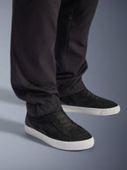 Alpinestars Flex-AST Cargo Pants - Short, urbana motorcykelbyxor, svarta, med avsmalnande ben och elastiska fållar, matchade med svarta Alpinestars-sneakers, modern urban körstil