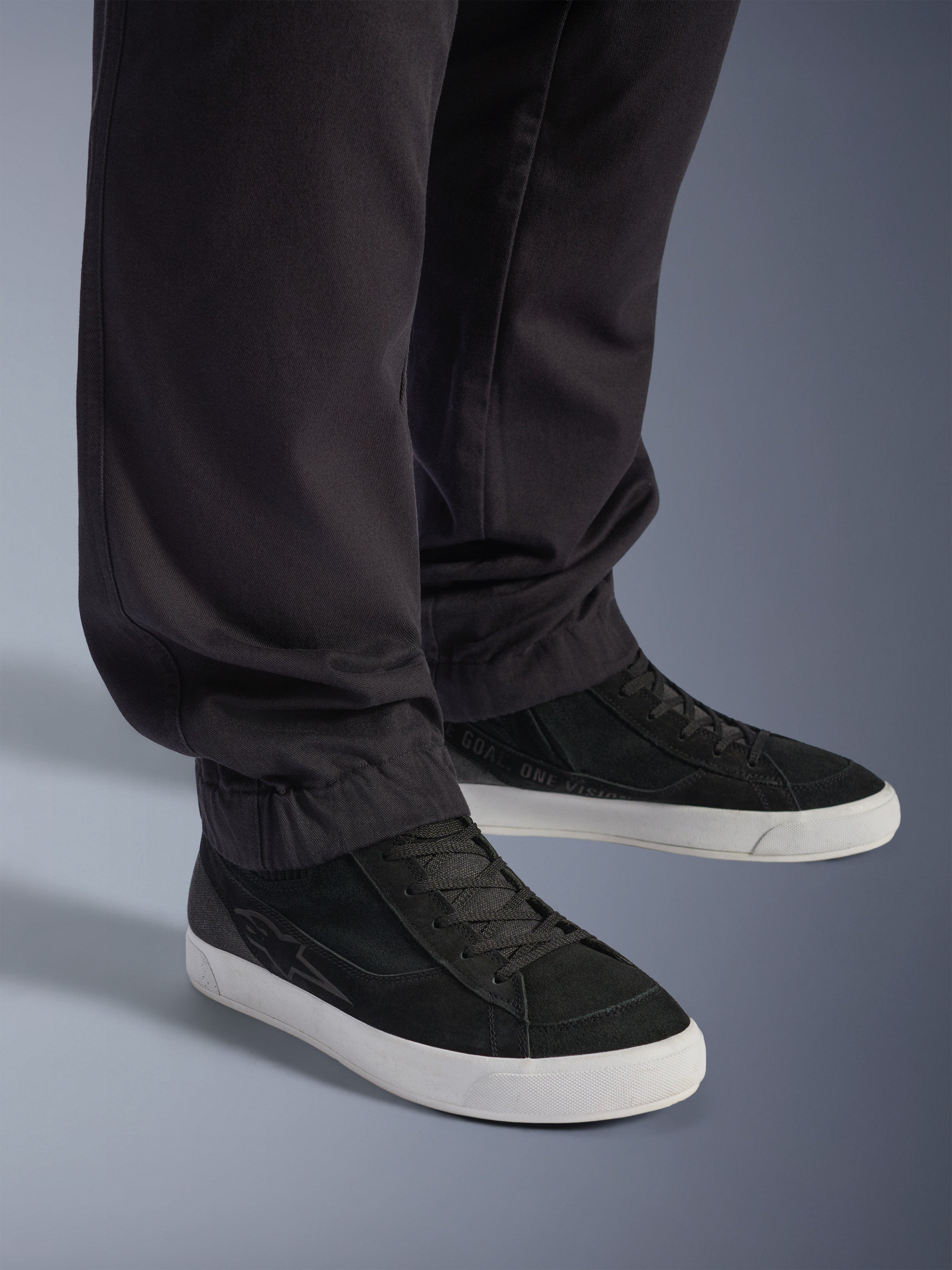 Alpinestars Flex-AST Cargo Pants - Short, urbana motorcykelbyxor, svarta, med avsmalnande ben och elastiska fållar, matchade med svarta Alpinestars-sneakers, modern urban körstil