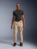 Alpinestars Flex-AST Cargo Pants - Short, ljusbeige urbana motorcykelbyxor, regular tapered passform med elastiska benslut, funktionella cargofickor och integrerat svart bälte med spänne, bärs av en manlig modell med ett svart baslager och sneakers.
