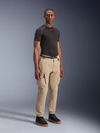 Alpinestars Flex-AST Cargo Pants - Short, ljusbeige urbana motorcykelbyxor, bärs av en modell med svart underställ och sneakers, med en regular avsmalnande passform, elastiska benslut och cargodesign med flera fickor.