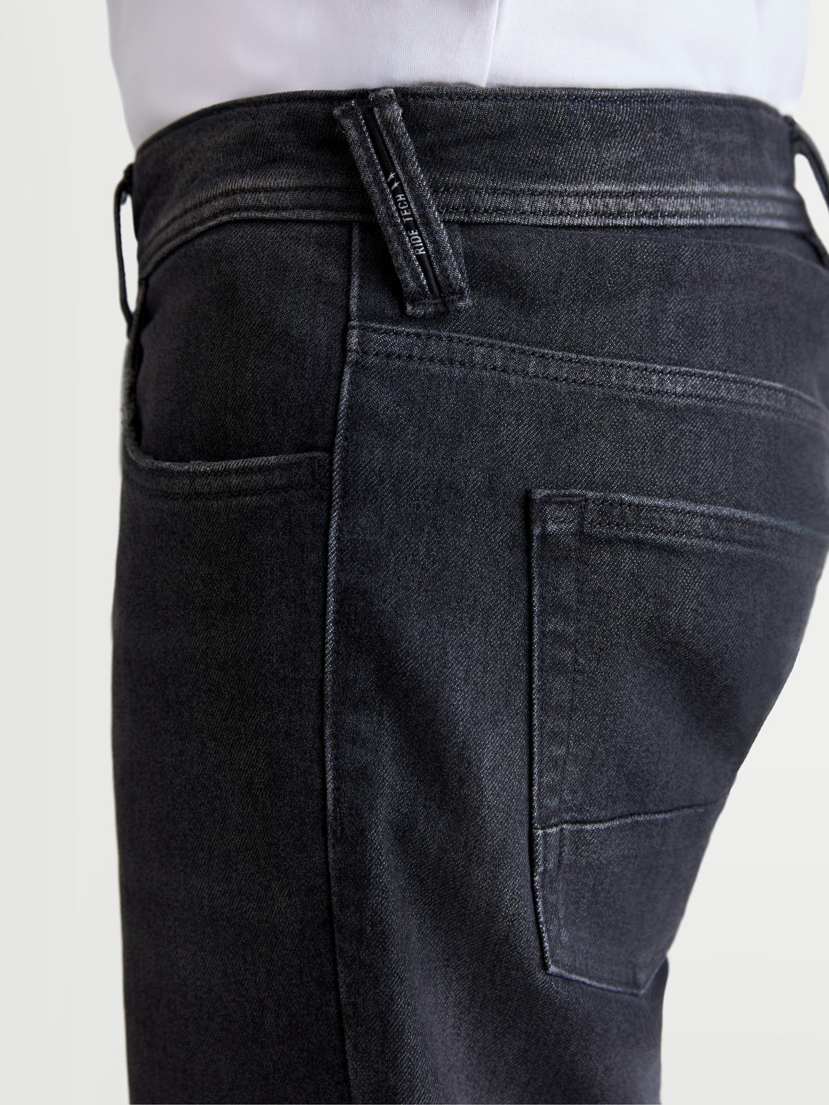 Alpinestars Flex Ast 8 Denim byxor, svarta motorcykeljeans för herr, närbild i sidovy som visar ficka och märkesdetalj på hällan på modell
