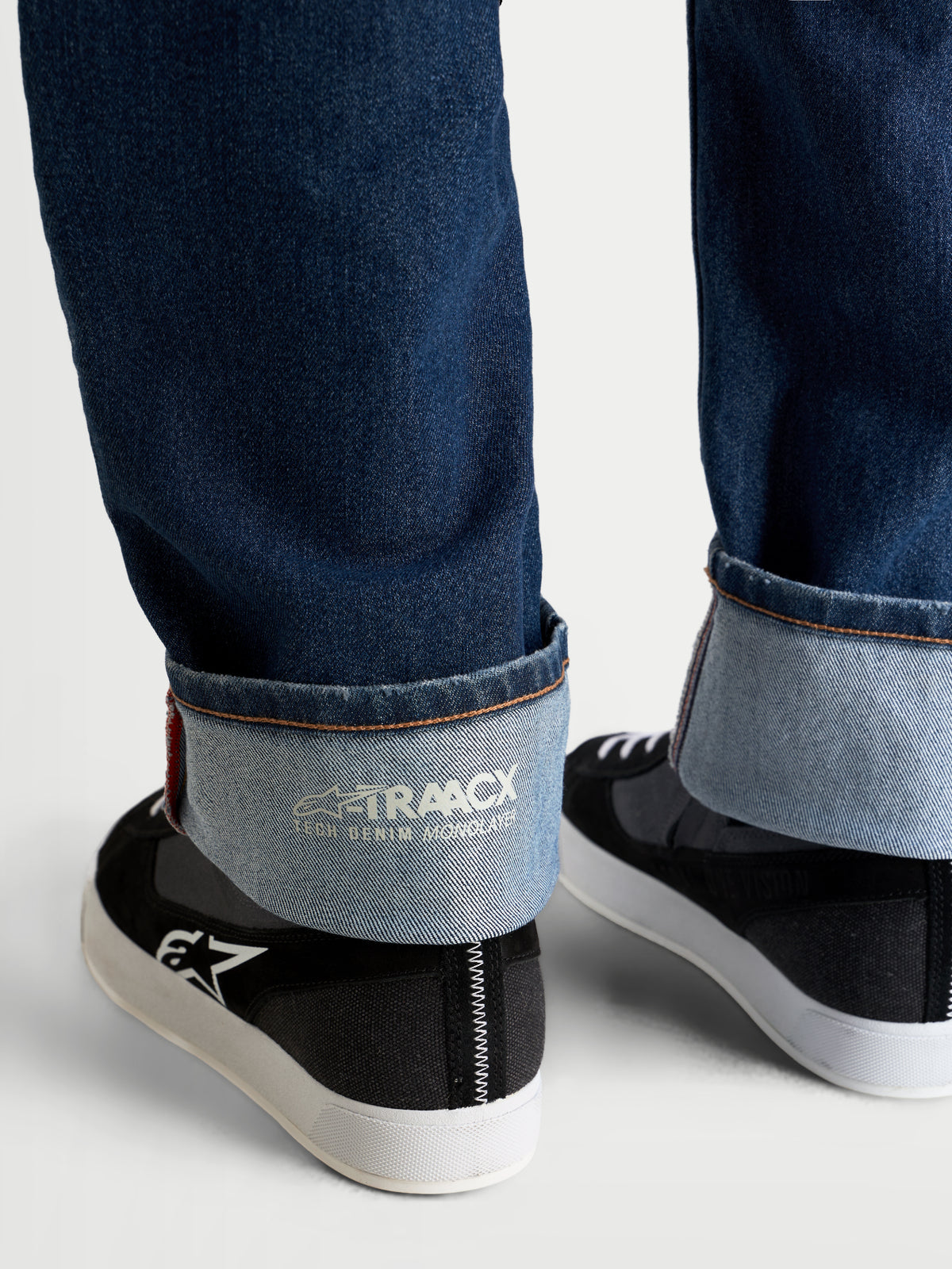 Alpinestars Flex Ast 8 Denim byxor, mellersta blå motorcykeljeans, närbild på uppvikta benslut med intern A-TRAACX enlagers teknisk denim-märkning och stadkantsfinish