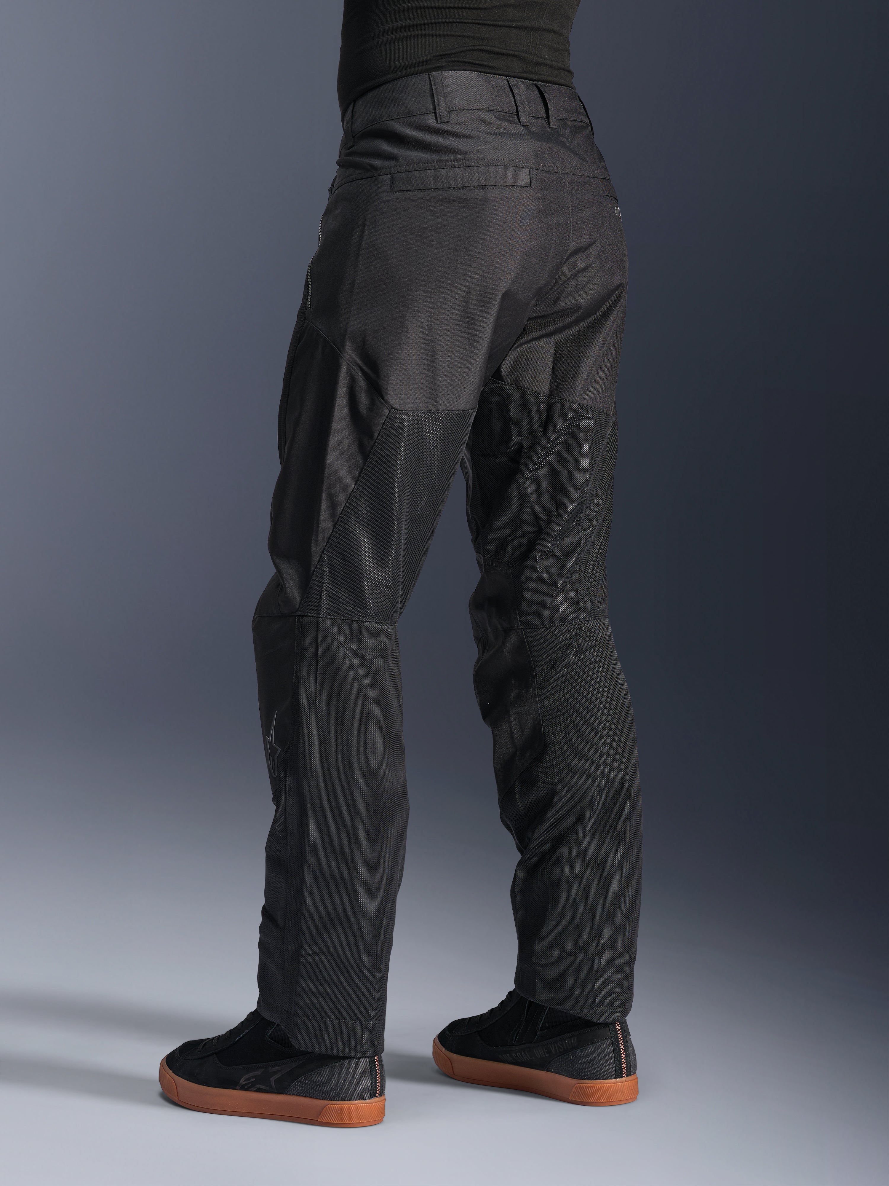 Alpinestars C-1 Air Pants, Urban Motorcycle Pants, Black, rear view showing large tech mesh panels on the back of the legs for ventilation, clean styling for city riding, worn with casual black sneakers.