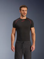 Alpinestars Aeroshell Airflow Pants, Black motorcycle pants, lightweight softshell textile, featuring a drawstring waistband and laser-perforated ventilation, worn with a black Alpinestars base layer shirt