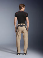 Alpinestars Acteon Pants in Sand, modern urban motorcycle pants viewed from the back, featuring black panels with white Alpinestars branding, tapered fit with zippers at the hem, worn with a black short-sleeved base layer and sneakers.