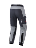 Alpinestars Maxdura Dual byxor, äventyrsbyxor för motorcykelkörning, mörkgrå och djupgrå, baksida som visar förstärkt sätesområde och ventilationsfickor med dragkedja och röda detaljer, designade för dual-sport-prestanda.
