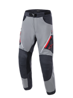 Alpinestars Maxdura Dual-byxor, äventyrsmotorcykelbyxor, mörkgrå och djupgrå, med förstärkta mörkgrå knäpaneler, röda ventilationsöppningar med dragkedja på låren, röd Astars-logotyp på låret och justerbart midjebälte med magnetspänne, designade för dual-sport-körning