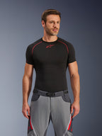 Alpinestars Maxdura Dual byxor, mörkgrå och djupgrå med röda detaljer, bärs med en svart underställströja med röda sömmar, atletisk passform med integrerat bälte med magnetspänne, slitstark MC-utrustning för äventyrsåkning