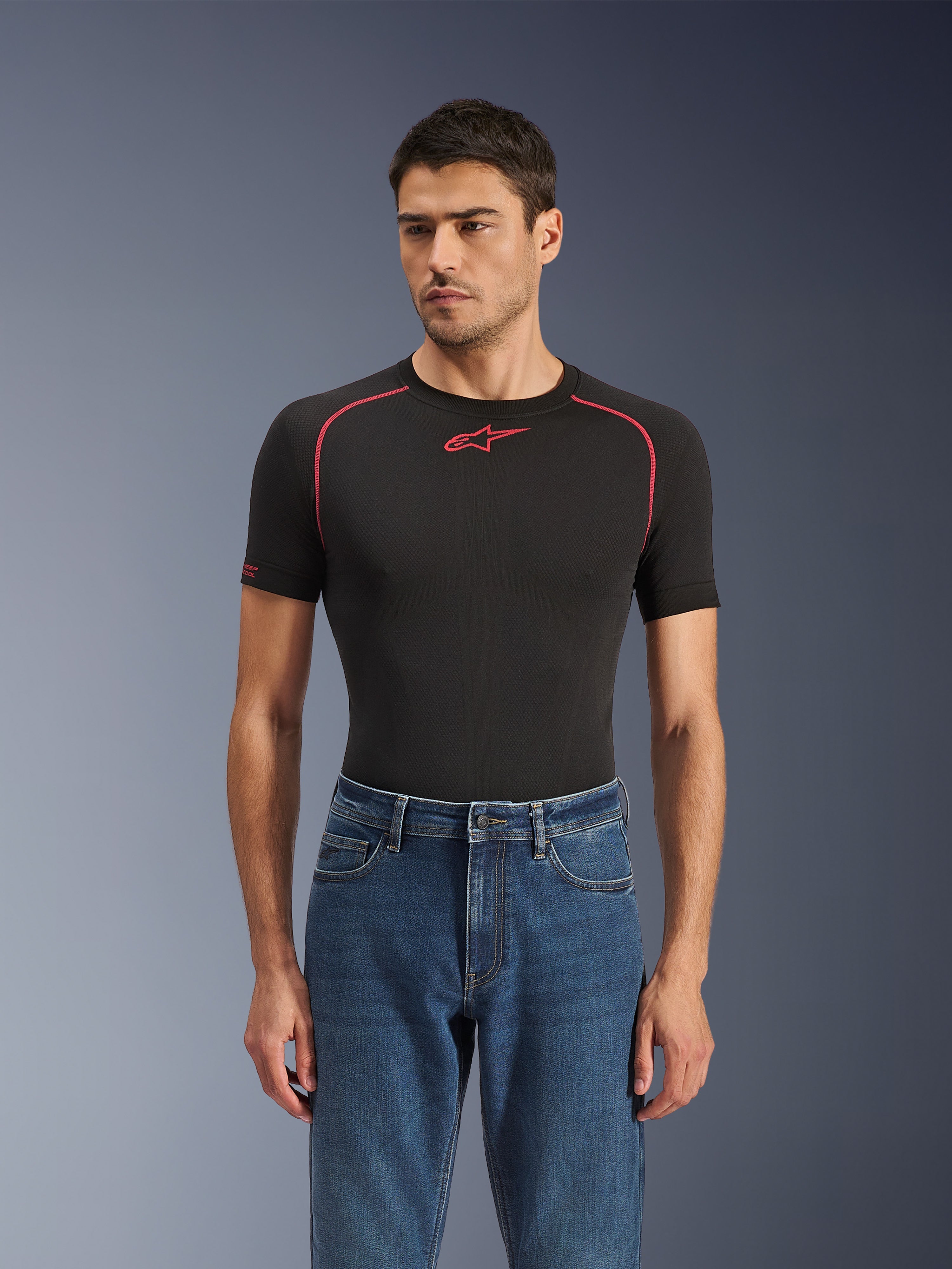 Alpinestars Flex-AST 5 Denim Pants i Indigo Washed, urbana motorcykeljeans med en avsmalnande passform, bärs av en manlig modell med ett svart kortärmat baslager med röda detaljer, avslappnad road-to-street-styling