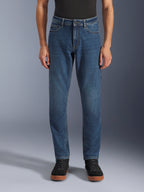 Alpinestars Flex-AST 5 Denim Pants, Urban Motorcycle Jeans, Indigo Washed Blue, front view showing a modern tapered fit and casual five-pocket styling, worn with a black top and sneakers, designed for urban riding comfort and protection.