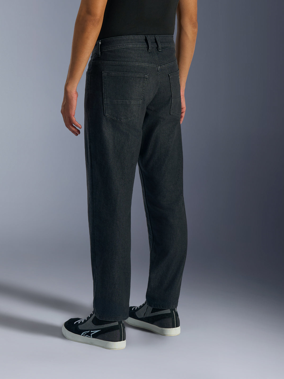 Alpinestars Flex-AST 5 Denim Pants, motorcykeljeans för herr i tvättad svart, vy snett bakifrån på modell som visar regular tapered-passform, bakfickor och konstruktion i monolager stretchjeans.