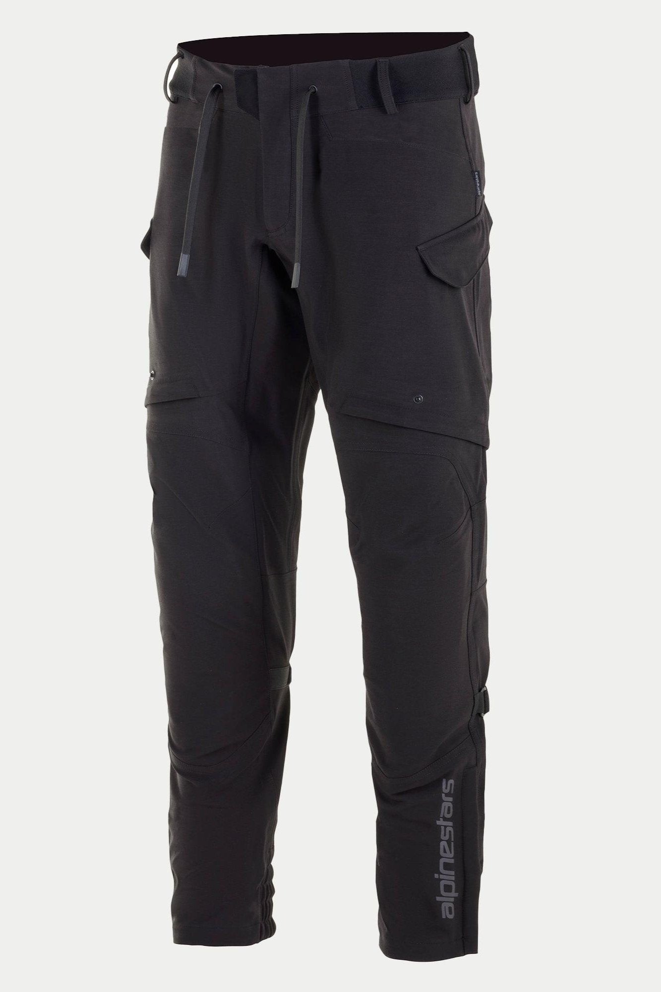 Alpinestars Juggernaut Waterproof-byxor, motorcykelbyxor, svarta, med dragsko i midjan och elastiskt midjeband, cargofickor med dragkedja på låren, vertikal Alpinestars-logotyp på underbenet, avslappnad softshell-textilkonstruktion