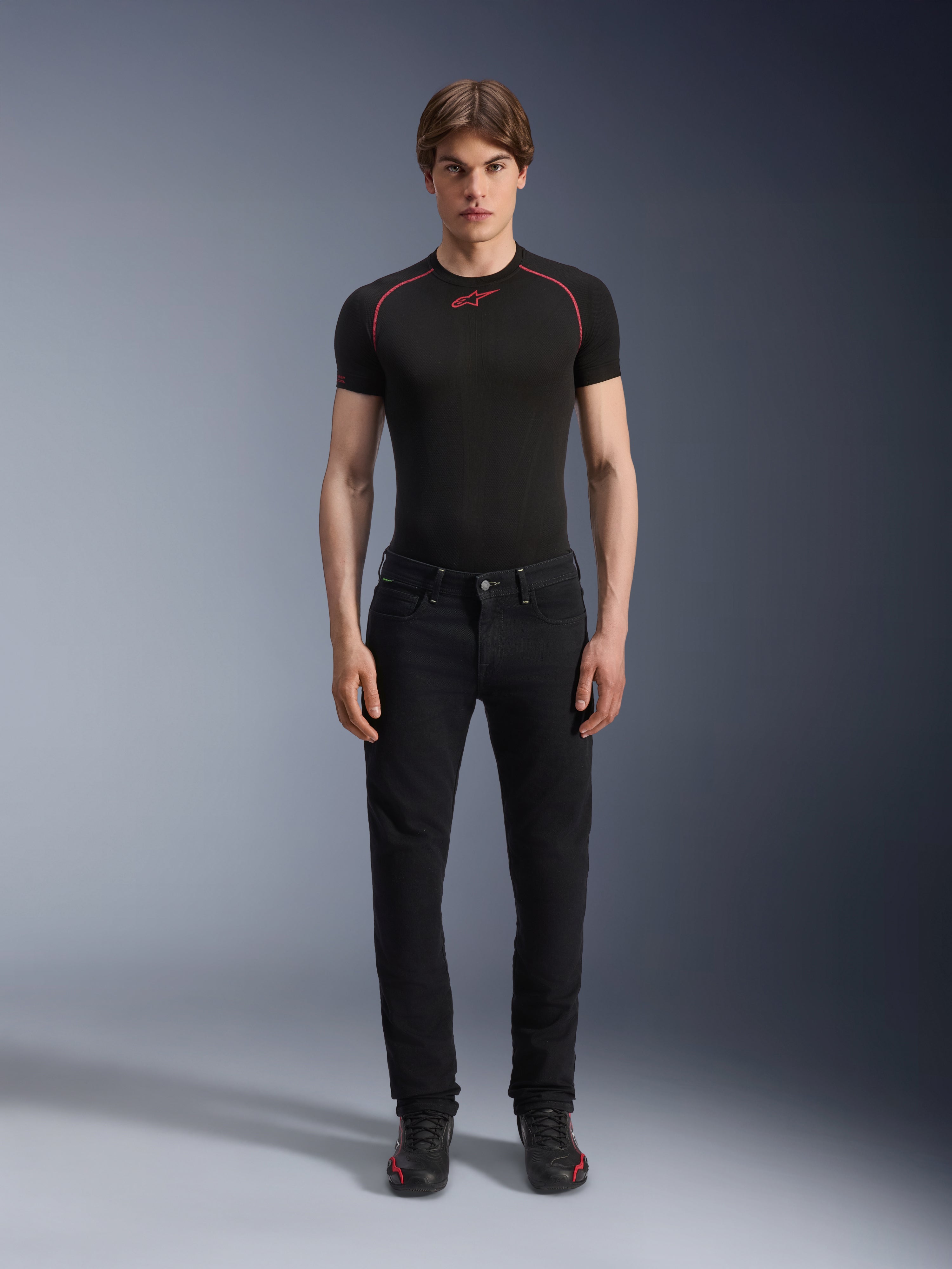 Alpinestars Copper V3 Denim Pants i Black Rinse, bekväm regular-passform med raka ben, bärs av en manlig modell med en svart baslagertröja med röda kontrastsömmar och svarta mc-sneakers, urban motorcykelensemble