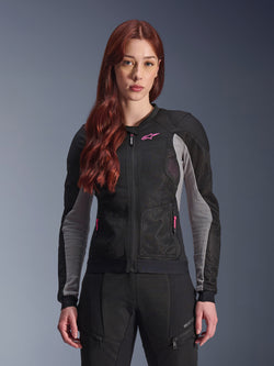 Alpinestars Stella Troop-Air Jacka för dam, MC-jacka i mesh, svart, askgrå och neonrosa, bärs av en modell med matchande körbyxor, ventilerad 2D-meshkonstruktion och rosa logotypdetalj, designad för urban sommarkörning