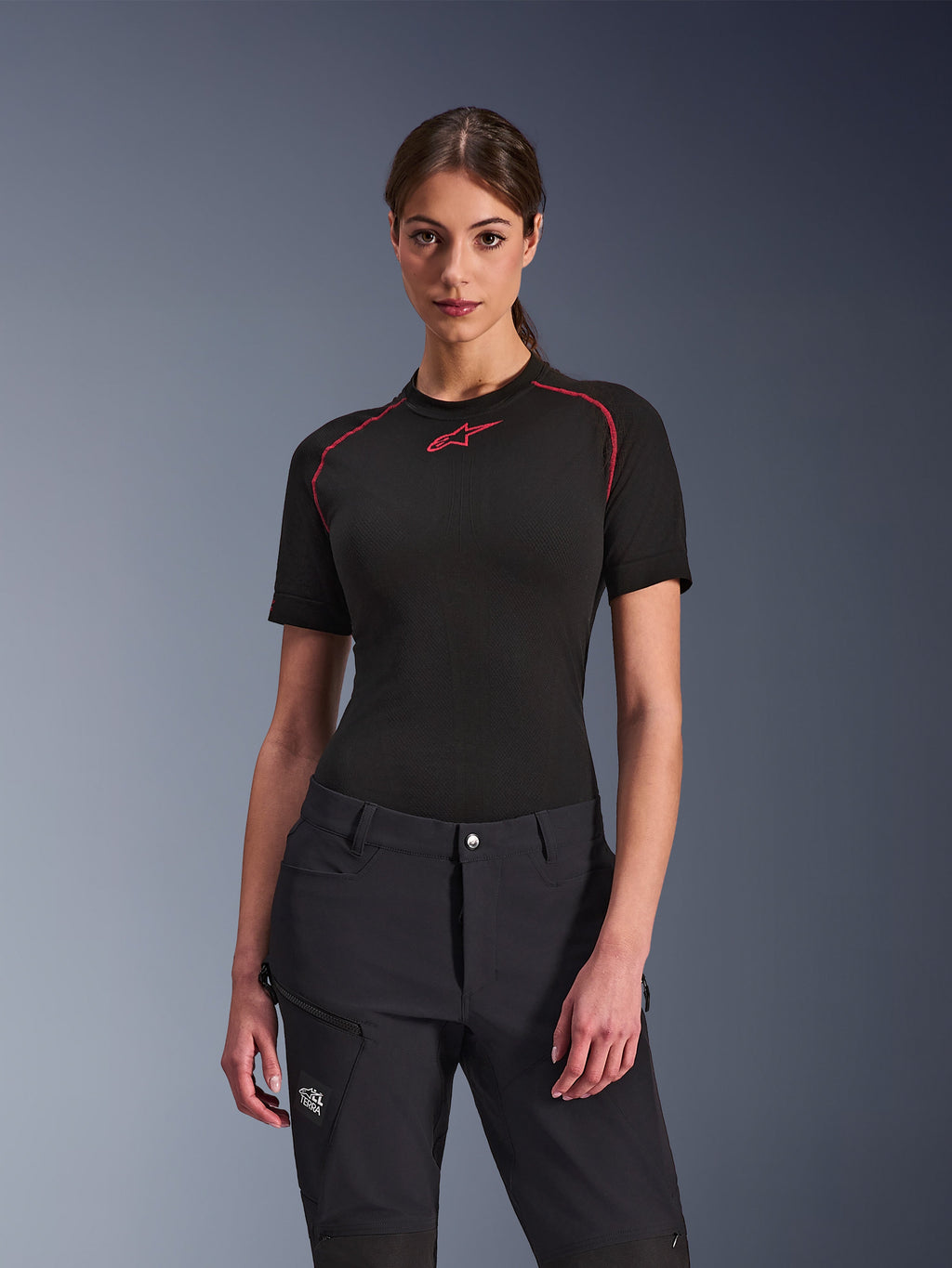 Alpinestars Stella Flex-AST Explorer-byxor för dam i svart, kombinerat med en svart kortärmad underställströja med röda detaljer, äventyrskläder med cargofickor och All Terra-logotyp