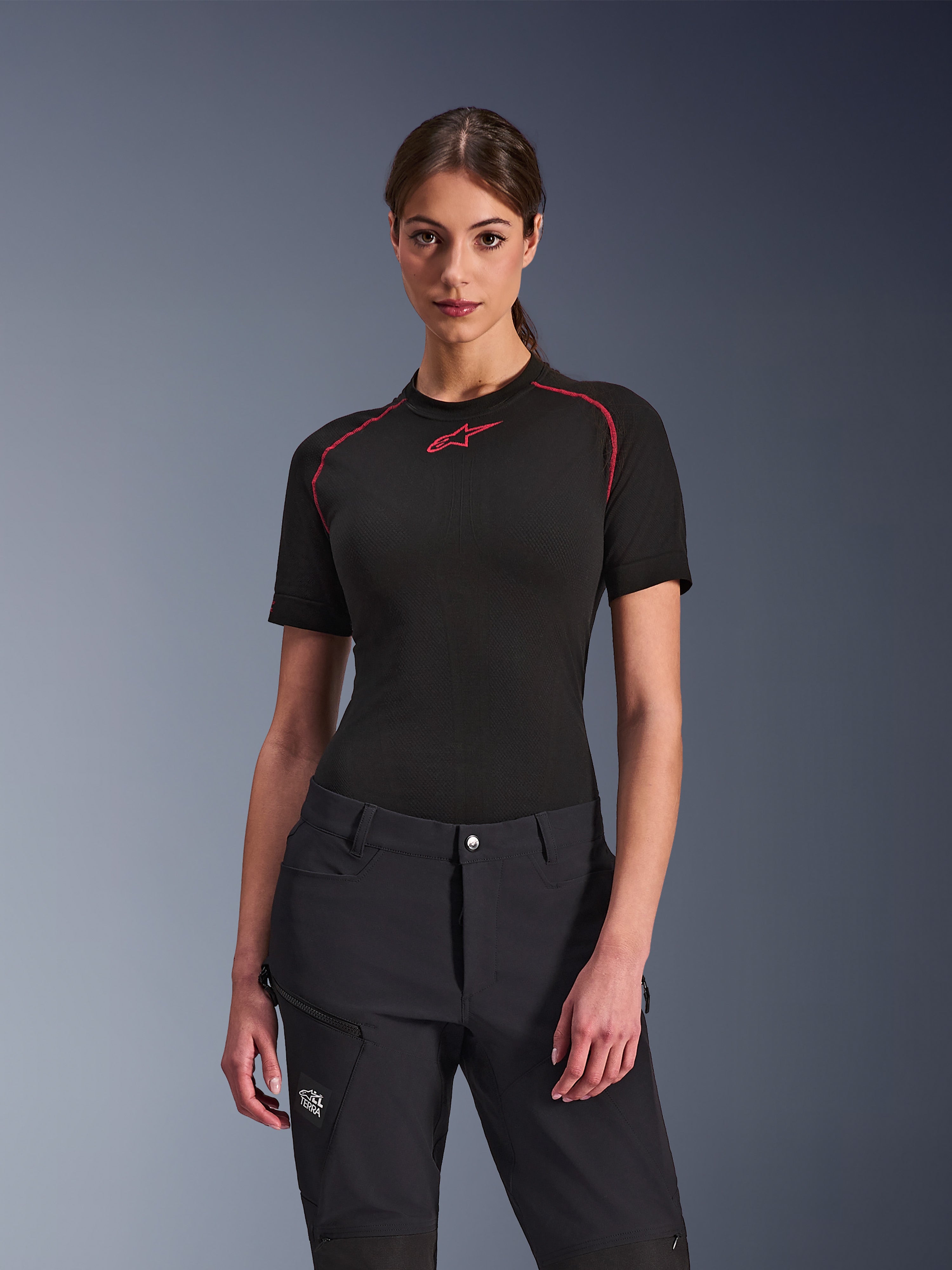 Alpinestars Stella Flex-AST Explorer-byxor för dam i svart, kombinerat med en svart kortärmad underställströja med röda detaljer, äventyrskläder med cargofickor och All Terra-logotyp