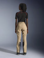 Alpinestars Woman Stella Flex-AST Explorer Pants in Sand, rear view on a model, paired with a black short-sleeved base layer and black boots, featuring reinforced seat panels and ergonomic textile construction for adventure touring.