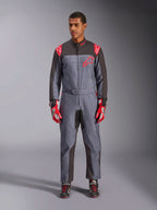 Alpinestars KMX-9 V3 Graphic 6 Suit, kartingdräkt, antracit, svart och röd, grått spräckligt grafiskt mönster, svarta paneler på insidan av armar och ben, röda Alpinestars-logotyper på axlar och bröst, bärs med röda racinghandskar och svarta skor
