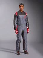 Alpinestars KMX-9 V3 Graphic 6 kartingdräkt, grå och antracit med röda detaljer, med ett unikt stänkmönster på bröstet och benen, matchat med röda racinghandskar och svarta kartingskor, helkroppsbild i studiomiljö.